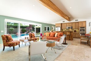 Living room, fully stocked kitchen, dining room area with pool views.