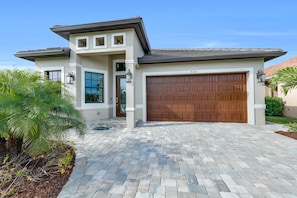 Stately entrance, large garage, and paver driveway