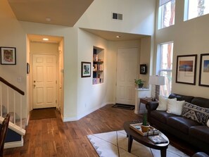 View from family room to living room and front door. Powder room on left. 