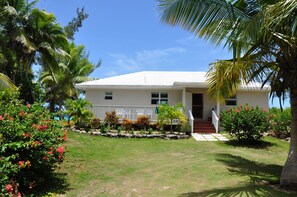 Gardens surround Mockingbird with palms,  tropical flowers and foliage. Private.