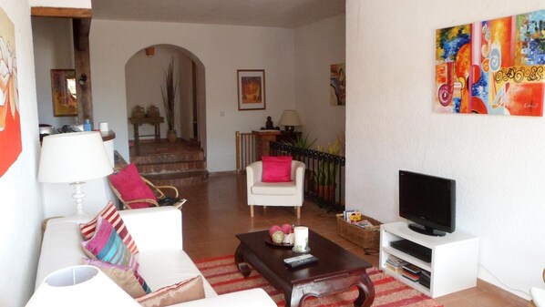 Main living area with kitchen to left and stairs down to right.