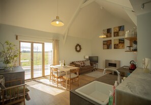 Open plan living and kitchen area with a fire.