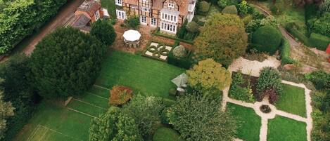 Aerial shot of The Grange and its gardens in the summer