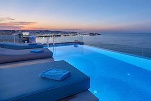 sunset and citylight of Hersonissos with breathtaking news at infinitypool