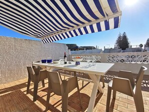 Veranda table, chairs, charcoal BBQ. Sea view and steps to pool. Black Rock view