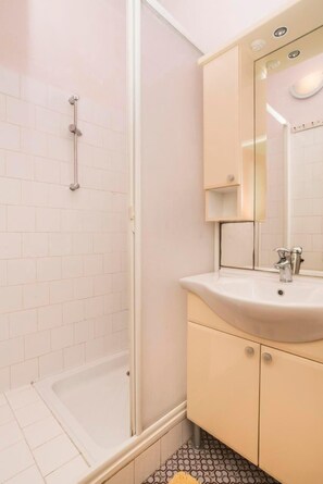 The bathroom with shower, sink, cabinet, and mirror