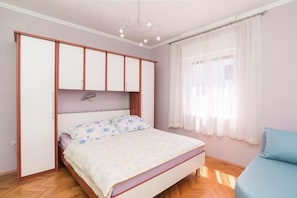 The bedroom with double bed, bridge wardrobe, sofa, air conditioner