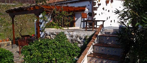 Blick vom Garten auf schattenspendende Pergola