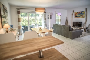 Vue depuis la cuisine ouverte sur la salle Ă manger et le salon