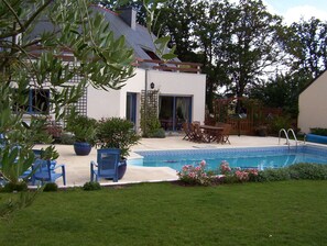 L'arrière de la maison, la terrasse, la piscine et le jardin clos