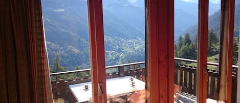 Le balcon avec une table et des chaises : un bon café avec vue sur la montagne !