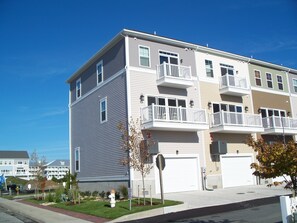 View of End Unit Townhouse with a 1 car garage & two parking spaces in the rear.