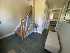 Entry way, view of first floor bedroom with Queen bed, stairs lead to main floor