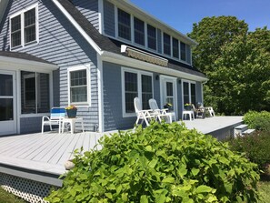 Generous sunny ocean view deck with 3 season screened in porch on left.