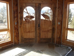 Hand carved elk doors downstairs near rec open area leading out to deck and yard
