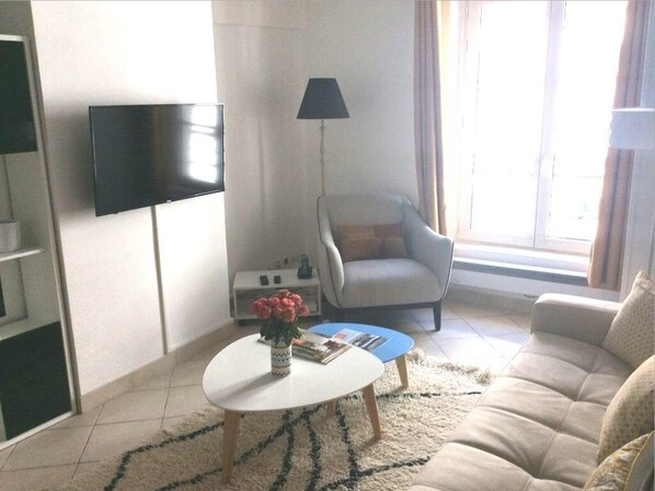 Relax in living room, HDTV, lots of light, facing the small quiet street below.
