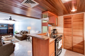 Open concept kitchen with bar seating and view of rec room.