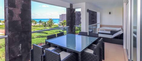 Ocean view terrace with Jacuzzi, lounge chairs, and patio table with seating for