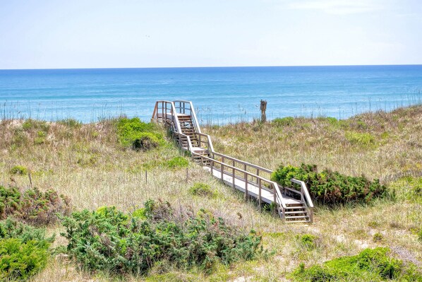 Beach access is easy from this 7-bedroom home with a path directly from the outdoor shower to the shared boardwalk to the beach.