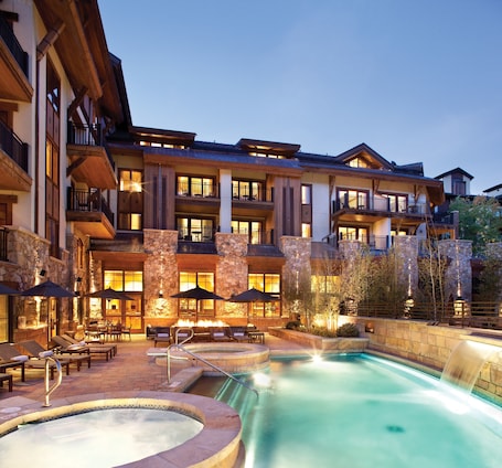 Outdoor heated pool with waterfall and hot tubs