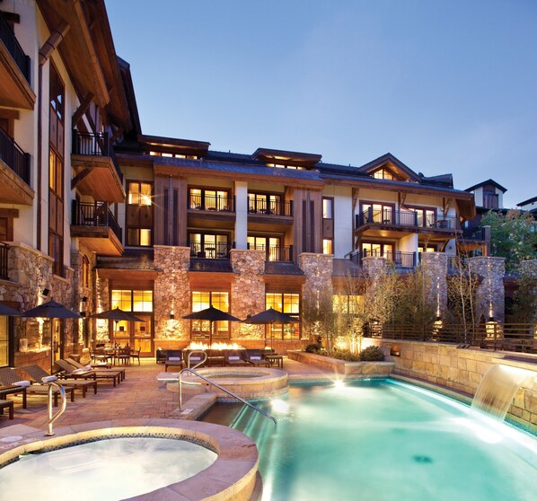 Outdoor heated pool with waterfall and hot tubs