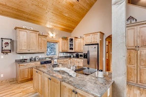 The luxurious well-appointed kitchen has custom cabinetry and counter tops. It is spacious with new stainless appliances.