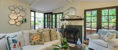  Bright sunny  living room french doors open on to  deck  