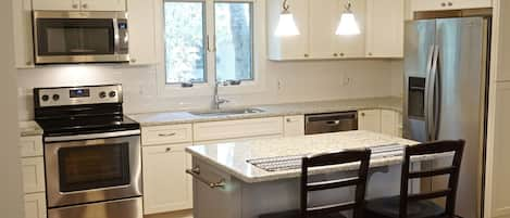 Beautiful and bright renovated kitchen with granite countertops and an island