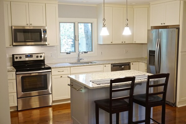 Beautiful and bright renovated kitchen with granite countertops and an island