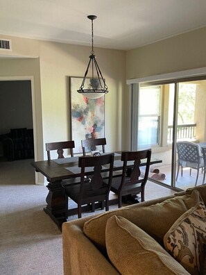 Dining area with den off to side, den has sofa and a desk.
