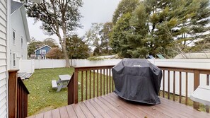 Back yard area off deck with grill.