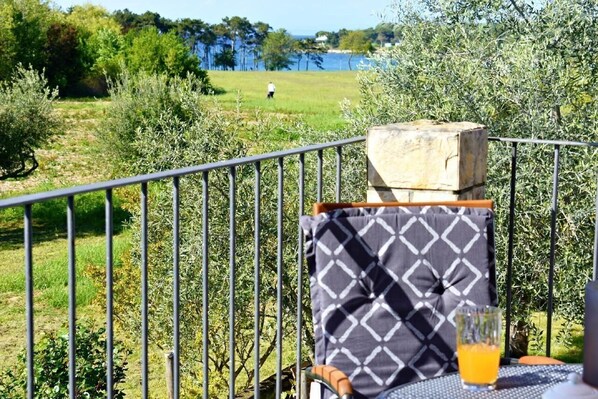 The sea view balcony with table, chairs, and umbrella