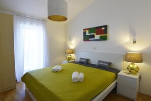 The large bedroom with a balcony and wardrobe