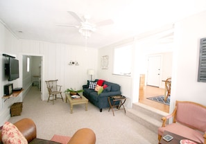 The spacious living area has a large flat screen TV, cable, and sound bar.