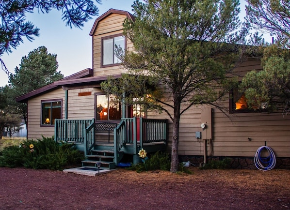 Front of our home surrounded by pinion pines.