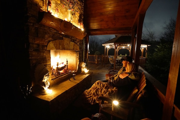 Night view of outdoor fireplace on top balcony off family room & master suite