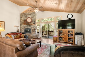 Living Room w/ Wood Burning Fireplace & Lake Views Off of Front Deck