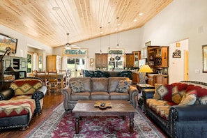 Living Room w/ Wood Burning Fireplace & Lake Views Off of Front Deck