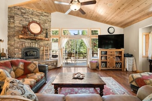 Living Room w/ Wood Burning Fireplace & Lake Views Off of Front Deck