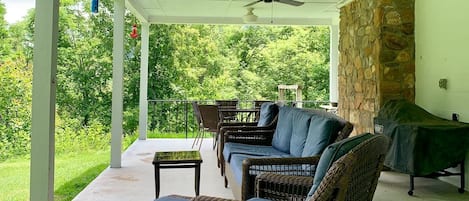 The side porch has relaxing views, comfortable seating, and dining area for 6+