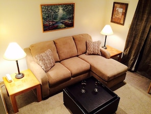Queen sofa bed / chaise feature. Wall-to-wall carpeting. Ottoman with storage.