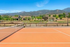 Private clay court with both the main and guest cabana in background 