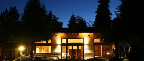 Main living space from yard at night.