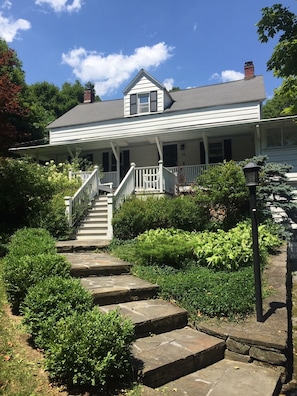 Flagstone steps up to the farmhouse and the front porch.