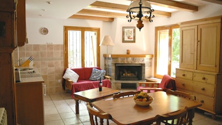 Living room with kitchen, dining area and fireplace.
