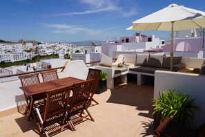 Large terrace with dining table and lounging area.