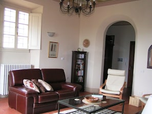 Large sitting room with comfortable seating, French doors to terrace and garden.