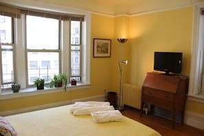 Bedroom includes writing desk and ample light from large windows