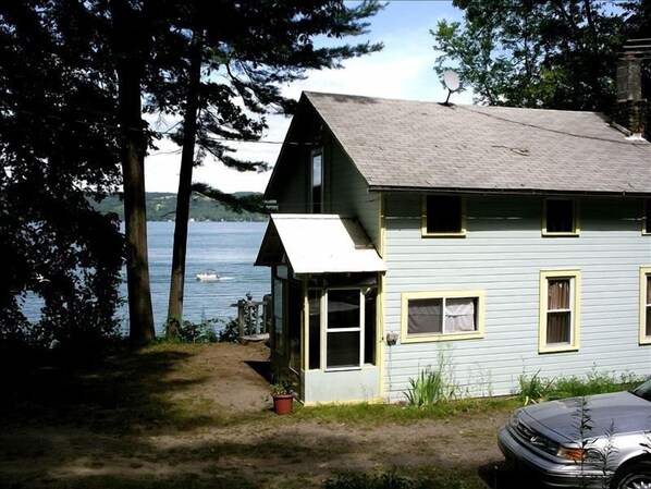 Rear view of Twin Pines w/parking behind cottage and Cayuga Lake to the east.