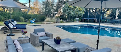The backyard has many spots to relax poolside.